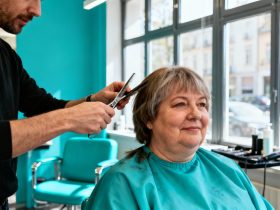 Femme de 55 ans avec double menton recevant des conseils pour une coupe de cheveux flatteuse dans un salon turquoise